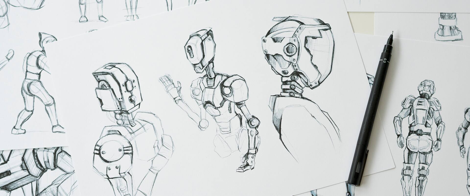 Detailed pencil and ink sketches of humanoid robot designs on paper, with a technical pen resting on one sheet.
