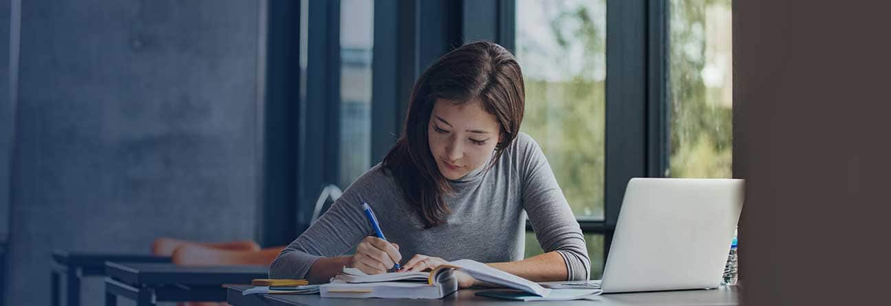 Student sitting in library doing homework.