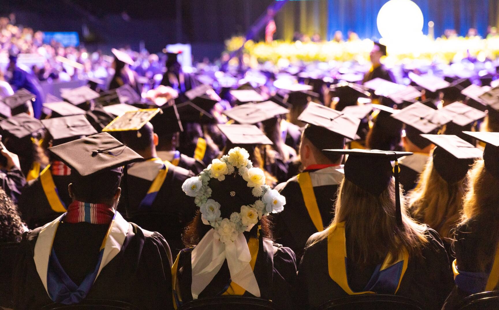 View of graduates seated at graduation from behind